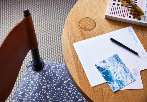 a wooden table with a chair with a pen and papers at Wayfinder Newport in Newport