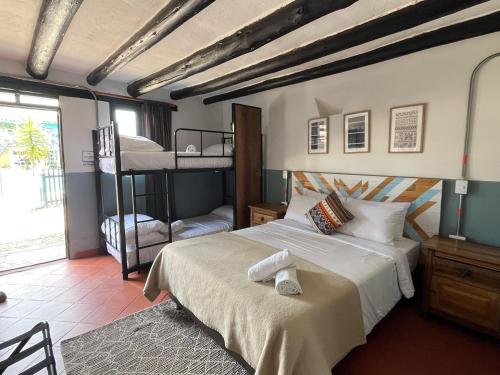 a bedroom with a bed and two bunk beds at Hotel Aceitunos in Villa de Leyva