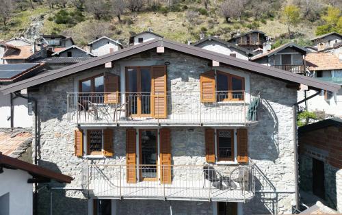 an old stone house with wooden shuttered windows at Rustico Maria Full House Lake View Escape in Vercana