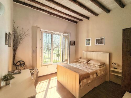a bedroom with a bed and a large window at Finca La Penúltima-Posada in San Rafael