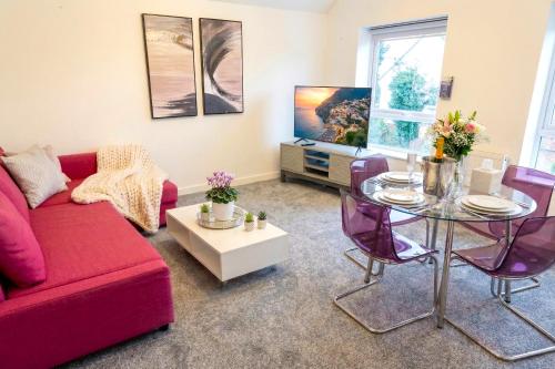 a living room with a red couch and a glass table at Paradigm House, Delightful 2-Bedroom Flat 4, Oxford in Oxford