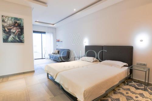 a bedroom with a bed and a couch in it at Dassine View - Luxe - Agadir - 4 Px in Agadir