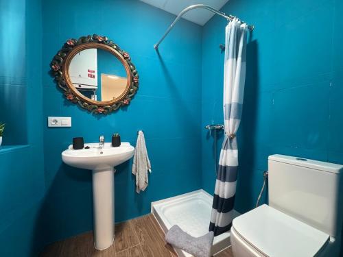 a blue bathroom with a sink and a mirror at Casa Lui Codrut in Alcalà de Xivert