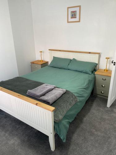 a bedroom with a bed with green sheets and pillows at Contractor Friendly - Long Stay Discount in Ipswich