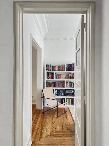 a hallway with a chair and a book shelf with books at Flattered to be in Lisboa in Lisbon
