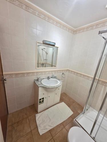 a bathroom with a sink and a shower at Casa Salema Praia Clube in Salema