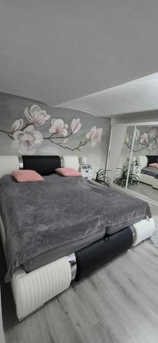 a bedroom with a bed with a black blanket and pink flowers at Ubytování Dobešov in Černovice