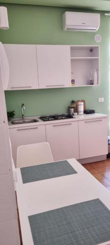 a kitchen with white cabinets and a sink at CORFÙ 19 Bed & Breakfast in Schiavonea