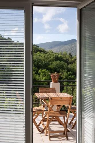 a wooden picnic table on a balcony with a view at Hillside Apartments in Sutorina