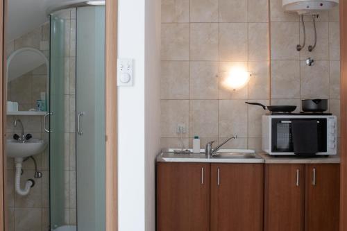 a bathroom with a sink and a microwave at Hillside Apartments in Sutorina