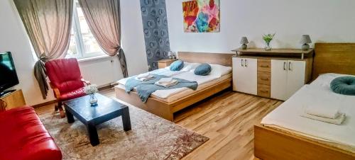 a bedroom with a bed and a couch and a chair at Hotel Orlan in Bratislava