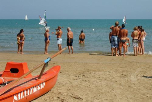 a group of people standing on the beach at Baia Degli Aranci Suite & Apartments in Vieste