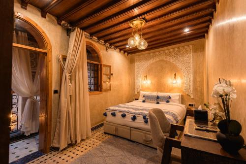 a bedroom with a bed and a desk and a window at Riad Golden in Rabat