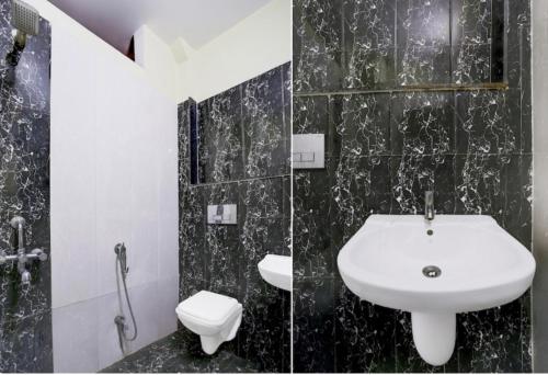 a black and white bathroom with a sink and a toilet at Vrinda's Villa in Maheshwar