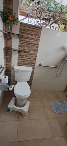 a bathroom with a toilet sitting on a tiled floor at Hostal Casa Las Flores in Masaya