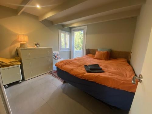 a bedroom with a bed with an orange comforter at Finca las Estrellas in Relleu