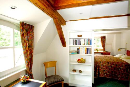 a bedroom with a bed and a book shelf at Seegut Blaue Blume in Buchenhain
