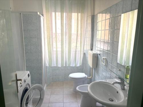 a bathroom with a toilet and a sink at Smart Convenient Apartments Orosei in Orosei