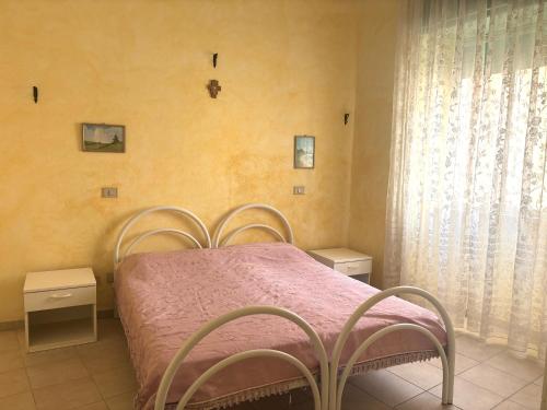 a bedroom with a bed with a pink blanket at Smart Convenient Apartments Orosei in Orosei