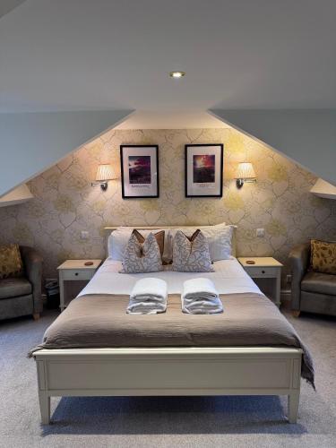 a bedroom with a large bed with two chairs at Springfield House in Grasmere