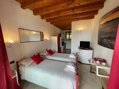 a bedroom with two twin beds in a room at La FIOCCHINA - Magic Place - apartments & studios in Garda Lake - countryside farmhouse, inside the middle of the lake between sky & water in Salò