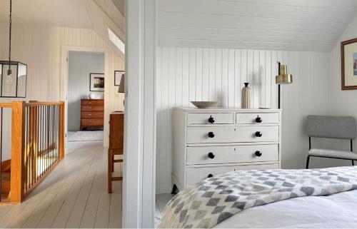 a bedroom with a white dresser and a bed at Taigh Druim in Elgol