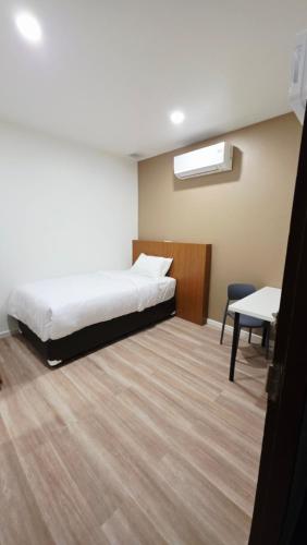 a bedroom with a bed and a table and a chair at SUP Hometel Phuket in Ban Thalat Choeng Thale