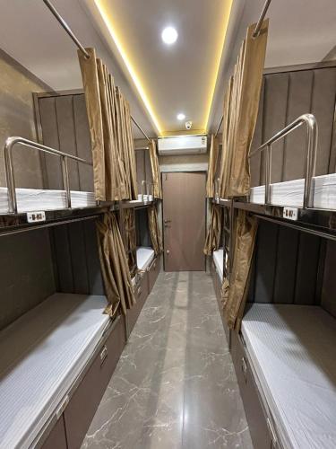 a room with several bunk beds in a room at Hotel Le Glance Rooms & Dormitory in Mumbai