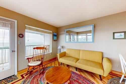 a living room with a couch and a table at Oceanfront Nye Beach condo with gorgeous corner view & beach access in Newport