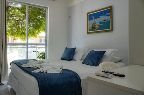 a bedroom with two beds and a desk and a window at PALM BEACH Porto das Dunas, apartamento todo climatizado TÉRREO a 350 metros Beach Park in Aquiraz