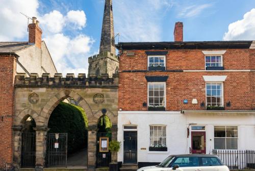 an old brick building with a car parked in front at Quirky Village Centre Apartment Above a Cocktail Bar, Castle Donington in Castle Donington