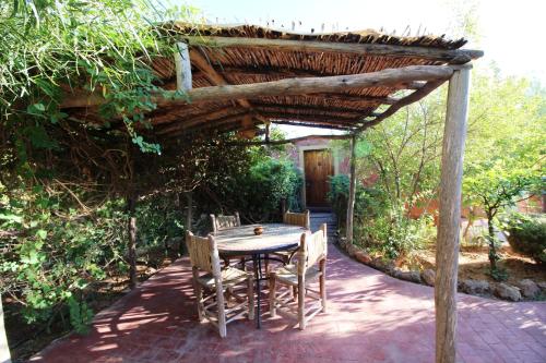 a table and chairs sitting under a wooden pergola at La Kasbah d'Ouzoud in Ouzoud