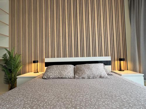 a bedroom with a bed and two lamps and a wall at Weekend apartment 3 in Sigulda