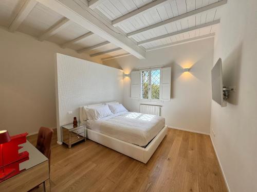 a white bedroom with a bed and a window at Santa Caterina 1604 Suites in Anzola dell'Emilia