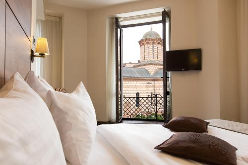 a bedroom with a bed with a view of a building at Europa Royale Bucharest in Bucharest