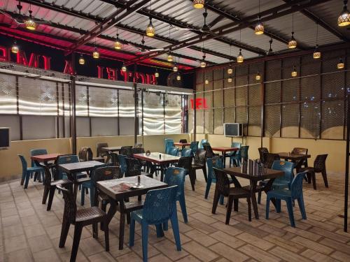 a restaurant with tables and chairs in a room at Hotel Ajmer Pride in Ajmer