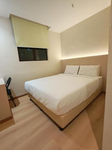 a white bed in a room with a window at The Loft hotel 68 in Butterworth
