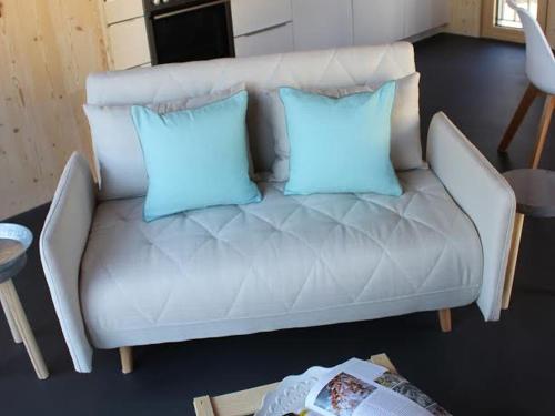 a white couch with two blue pillows on it at Dorfschmiede in Hüttlingen