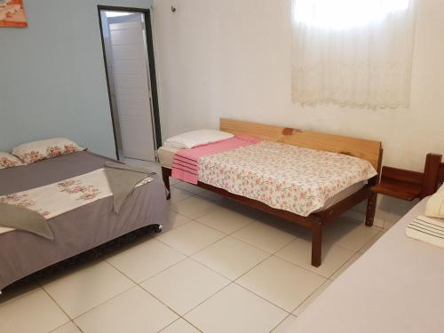 a bedroom with two beds and a mirror in it at Casa Dos Vovôs Pousada em Canoa Quebrada in Aracati