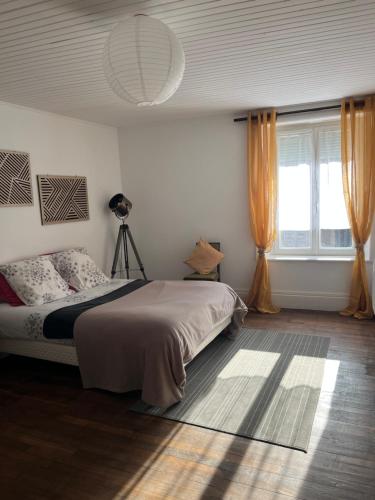 a bedroom with a bed and a window at La ferme in Savigny