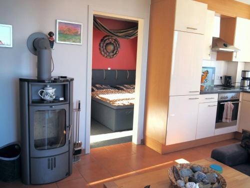 a living room with a stove and a bedroom at Meerblick 9 - Großenbrode in Grossenbrode