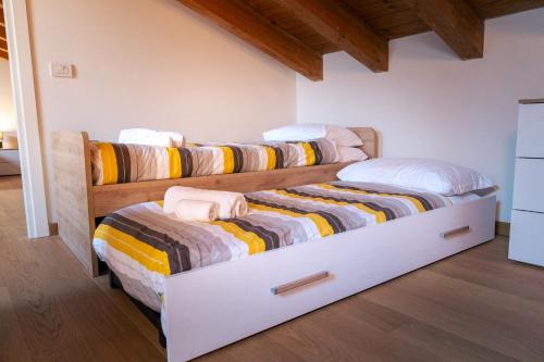 two twin beds in a room with wooden ceilings at Relais Terre Divino 1 in Ponton