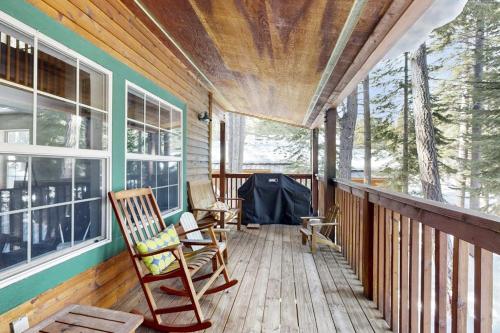 a porch of a house with two rocking chairs at Tranquil cabin near ski slopes & trails with wraparound deck & pool table in Truckee