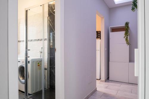 a bathroom with a washing machine and a glass door at Victory76 - Hospital, M3, Linate in San Donato Milanese