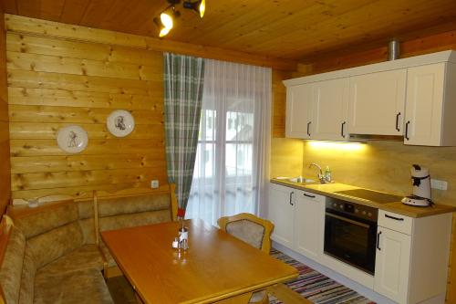 a kitchen with white cabinets and a table with a sink at Haus Strobler in Going am Wilden Kaiser