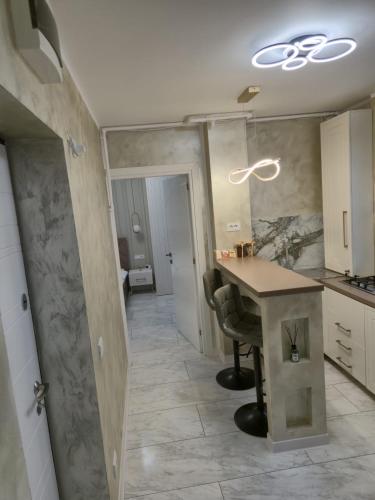 a kitchen with a table in the middle of a room at Edward Luxury Studio in Slănic-Moldova