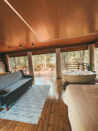 a large room with a tub and a large window at Cabana Penélope in Alfredo Wagner