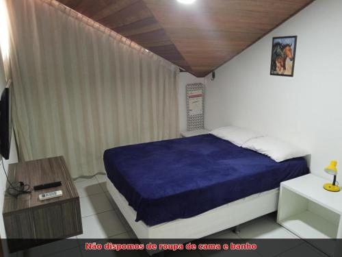 a bedroom with a bed with a blue blanket at Monte Castelo Flat Temporada in Bezerros