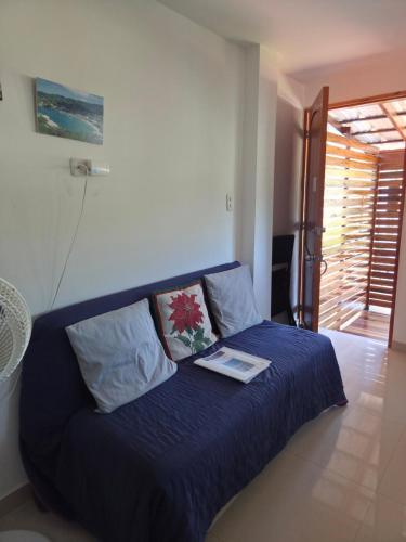 a bedroom with a blue bed with a book on it at Cabañas Annapurna - Cabaña #12 in Taganga