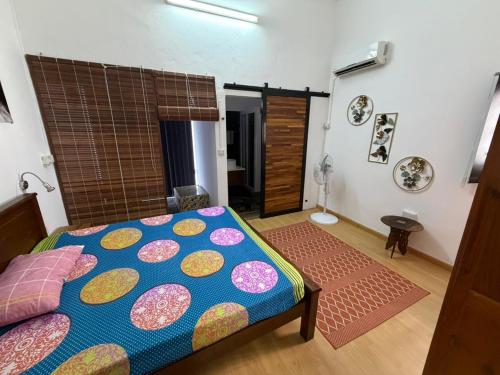 a bedroom with a bed with a colorful bedspread at PRIBO's in Flic-en-Flac